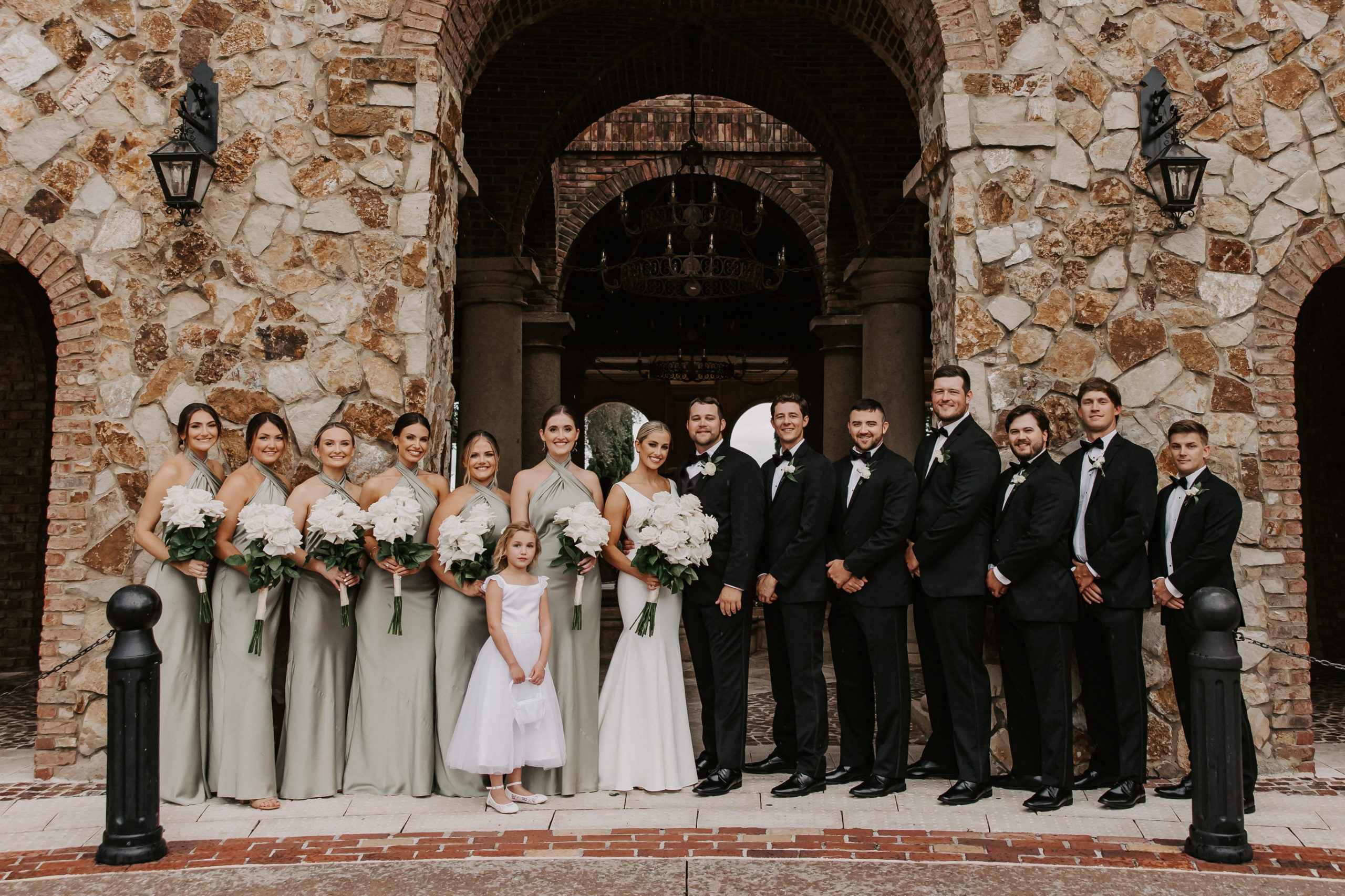 Groomsmen stayed cool in a classic black suit while bridesmaids were stunning in a chic sage gowns for this elegant and timeless wedding. 